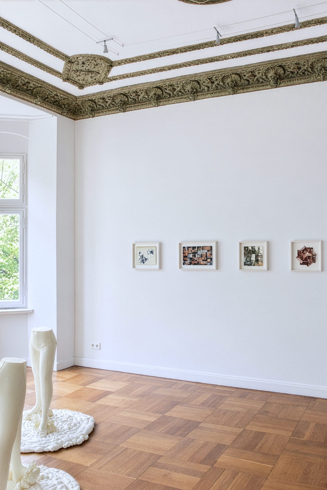 Installation view with foam sculptures by Maria Wallace in the foreground and framed montages on the wall